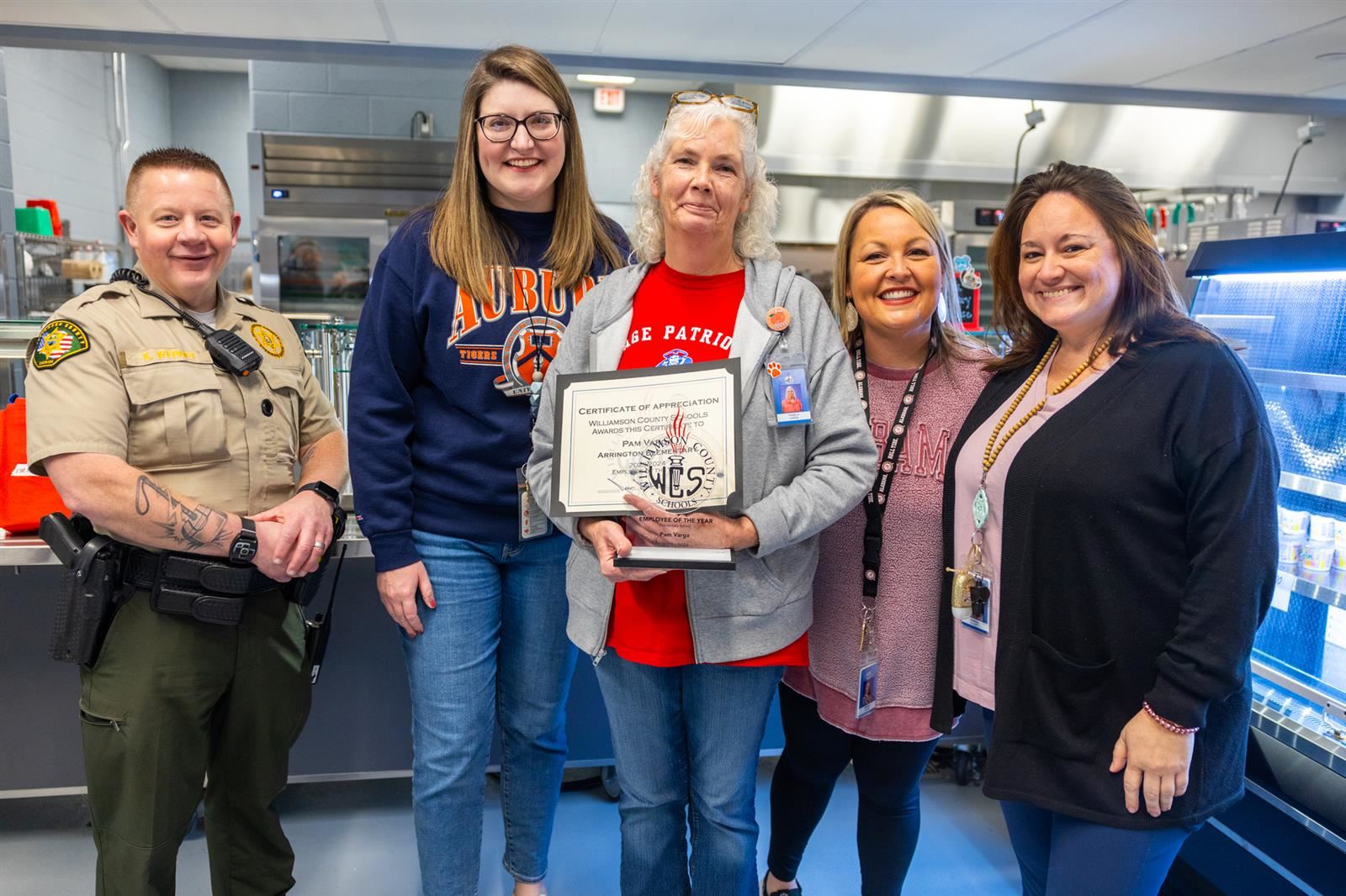 group of women, principals and sro with certificate and trophy